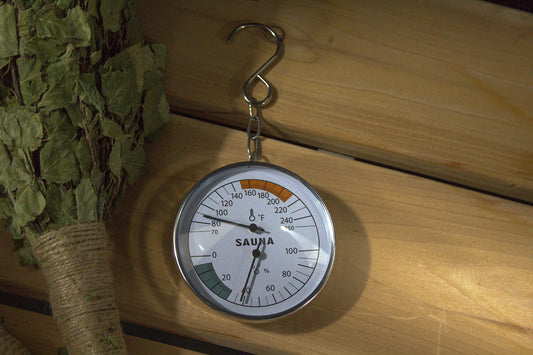 Sauha thermometer on a wooden surface with green leaves in the background