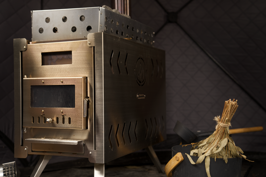 The portable sauna tent and the folding stove packed neatly into their durable carrying bags, demonstrating compact storage and ease of travel.